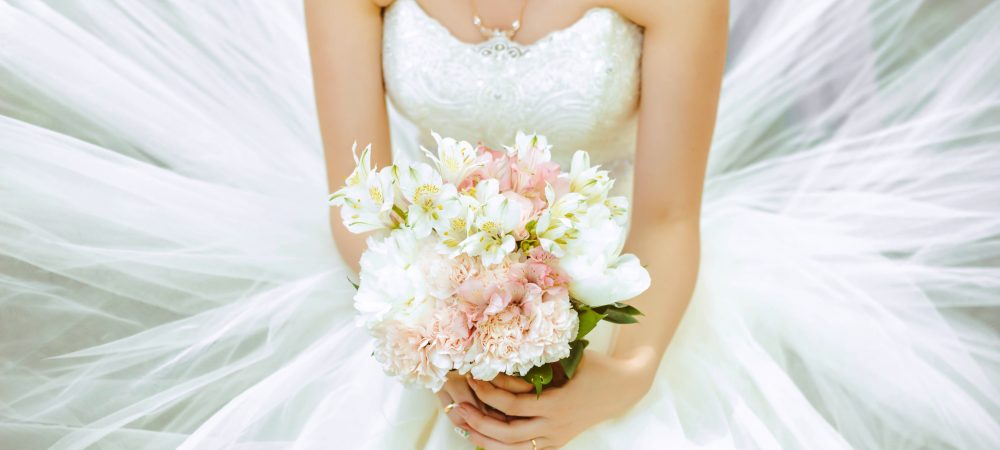 Bouquet of the bride in a magnificent white dress.